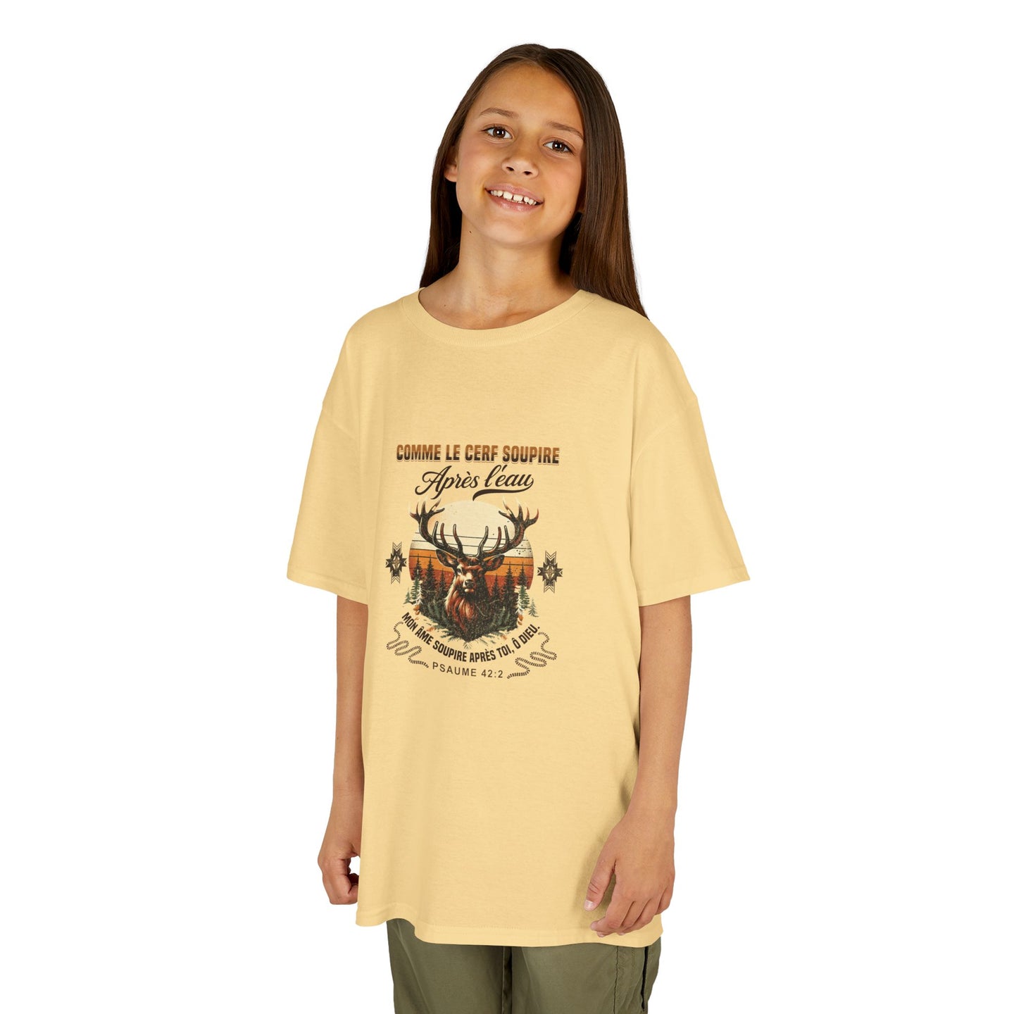 Une jeune fille porte un t-shirt beige en coton avec une illustration de cerf et un verset biblique.