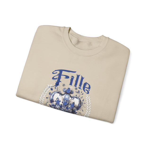 Sweat-shirt beige plié avec une couronne bleue et le mot Fille imprimés sur le devant.