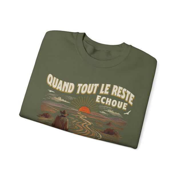 Sweat-shirt vert olive plié avec une illustration de cowboy face à un coucher de soleil.