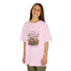Une jeune fille porte un t-shirt rose pâle orné d'un motif floral vintage et de papillons.