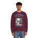 Un homme porte un sweatshirt bordeaux avec une illustration religieuse et le texte Il est ressuscité.