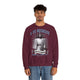 Un homme porte un sweatshirt bordeaux avec une illustration religieuse et le texte Il est ressuscité.