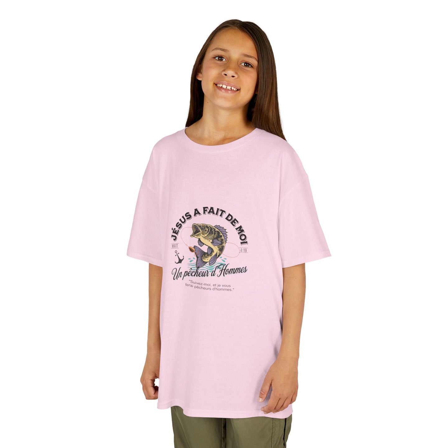 Une jeune fille porte un t-shirt rose clair avec une illustration de poisson et un texte religieux.