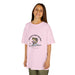 Une jeune fille porte un t-shirt rose clair avec une illustration de poisson et un texte religieux.
