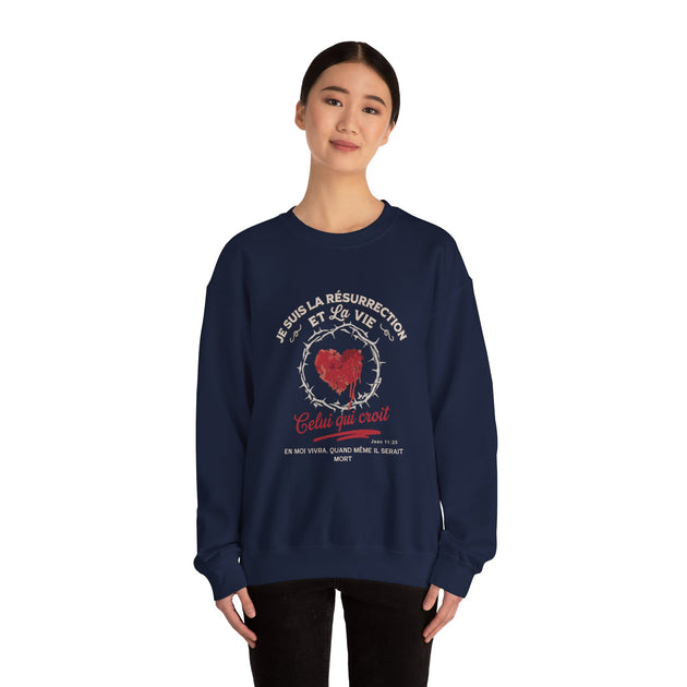 Une femme porte un sweat-shirt bleu marine avec un motif de cœur couronné d'épines et du texte.