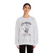 Une femme porte un sweat-shirt gris chiné avec une empreinte de main et un texte religieux.