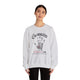 Une femme porte un sweat-shirt gris chiné avec une empreinte de main et un texte religieux.