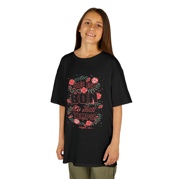 Une jeune fille porte un t-shirt noir avec un motif floral et le texte Dieu est bon en tout temps.