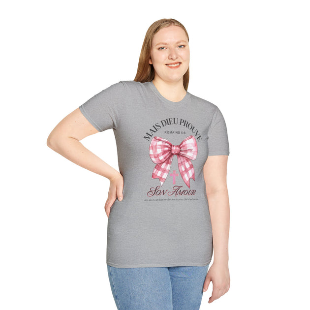Une femme porte un t-shirt gris avec un motif de nœud vichy rose et une croix chrétienne.