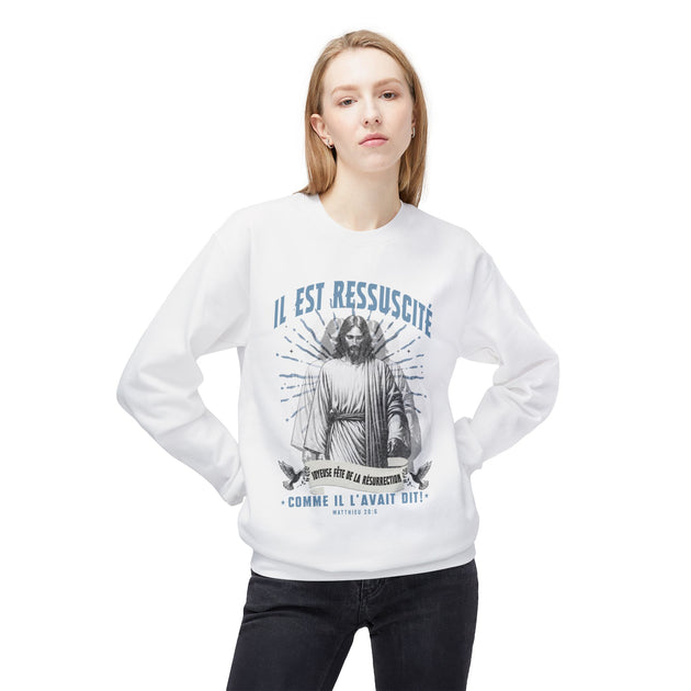 Femme portant un sweatshirt blanc avec une illustration vintage de Jésus et texte religieux.