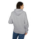 Une femme porte un sweat à capuche gris uni vu de dos.