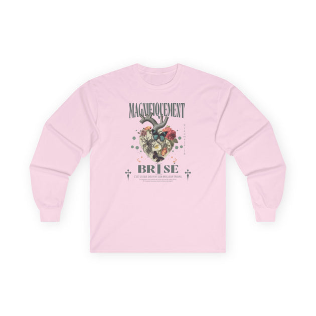 T-shirt rose à manches longues avec un motif floral et religieux centré sur la poitrine.