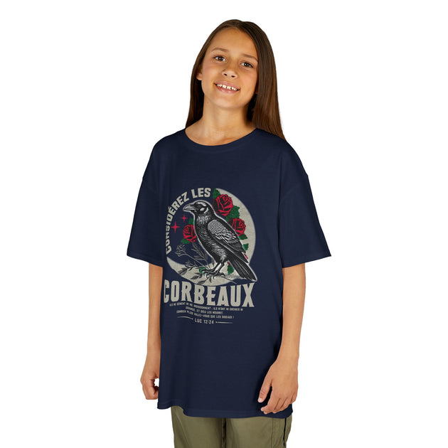 Une jeune fille porte un t-shirt bleu marine illustré d'un corbeau et de roses avec du texte.