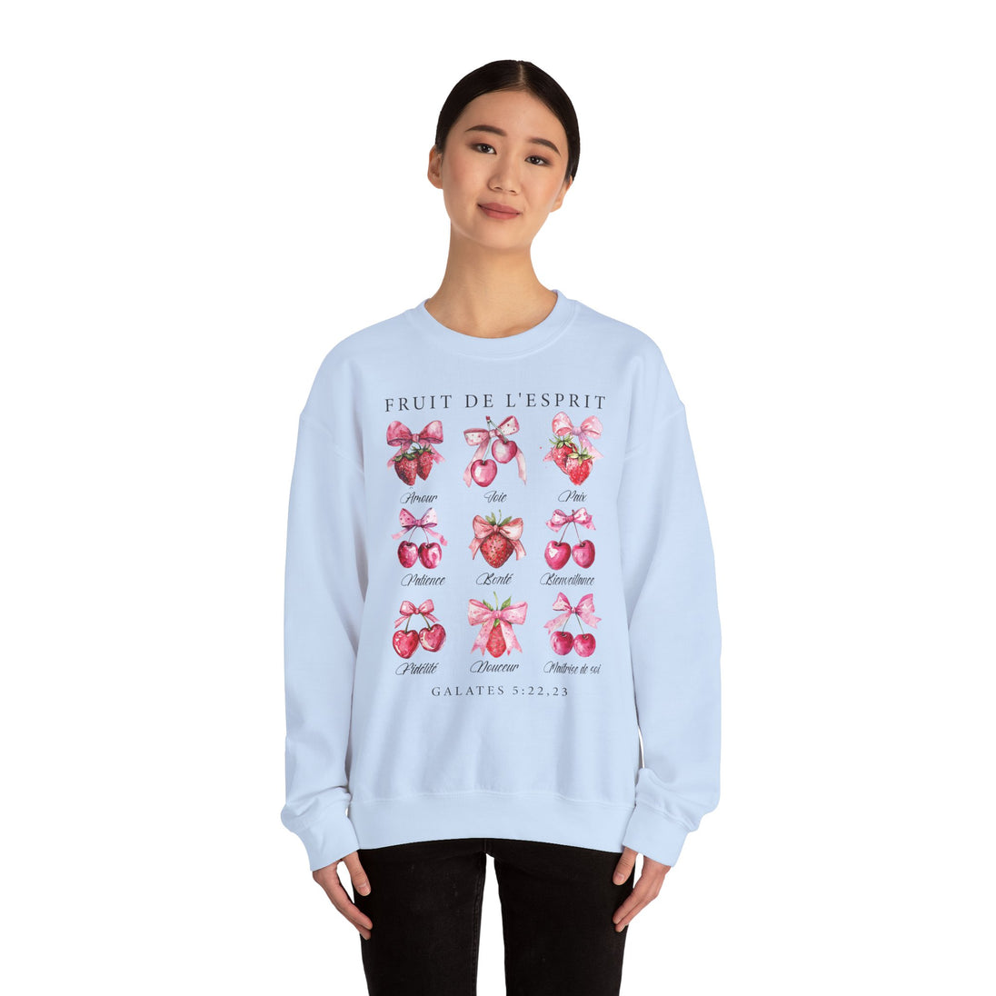 Une femme porte un sweat-shirt blanc illustré de fruits et de nœuds avec le texte Fruit de l'Esprit.