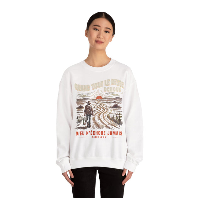 Une femme porte un sweat-shirt blanc avec une illustration de cow-boy et le texte Dieu n'échoue jamais.