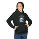 Une femme porte un sweat à capuche noir avec une illustration religieuse sur la poitrine.