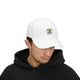 Un homme porte une casquette blanche en coton avec un logo de poisson brodé sur le devant.
