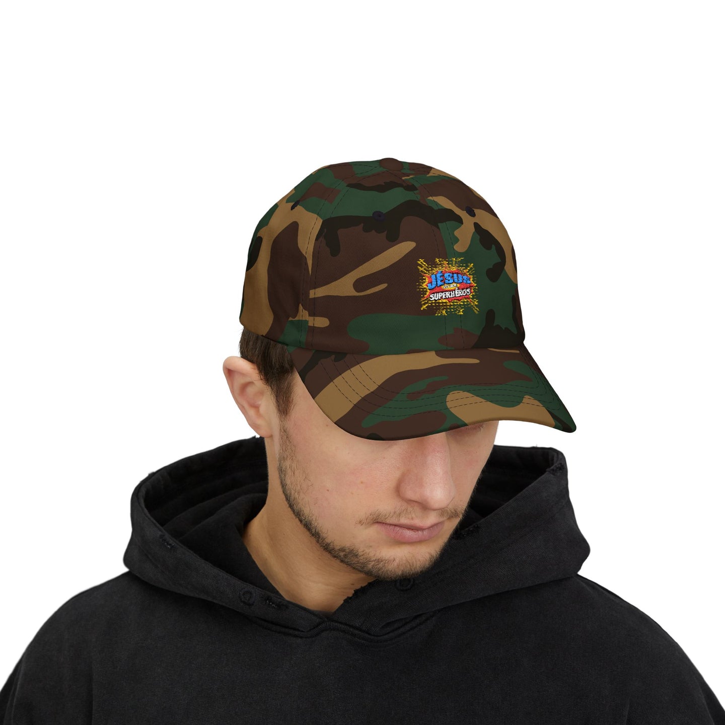 Un homme porte une casquette en tissu camouflage avec le logo Jesus est mon Superhéros.