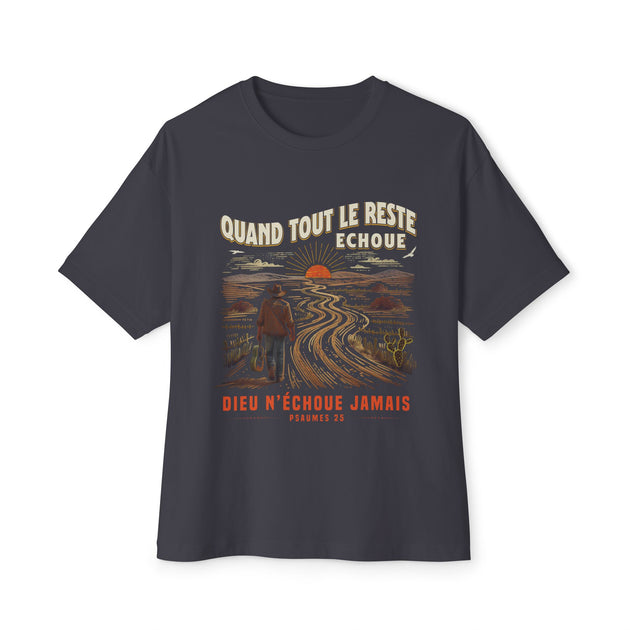 T-shirt gris foncé à coupe ample avec une illustration de voyageur et un texte religieux en français.