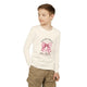 Un enfant porte un t-shirt blanc à manches longues avec un motif de nœud rose et une croix.