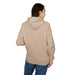 Une femme porte un sweat à capuche beige uni vu de dos sur un fond blanc.