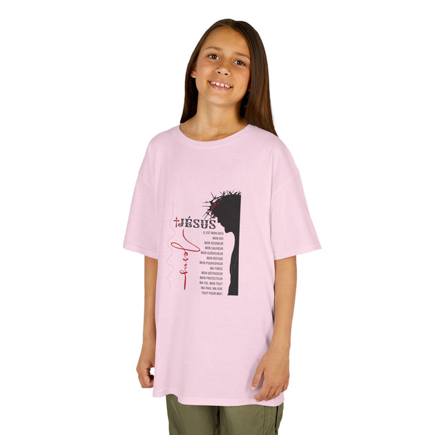 Une jeune fille porte un t-shirt rose clair orné d'une illustration de Jésus et de textes religieux.