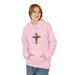 Une femme porte un sweat à capuche rose pâle orné d'une croix florale et de l'inscription française.