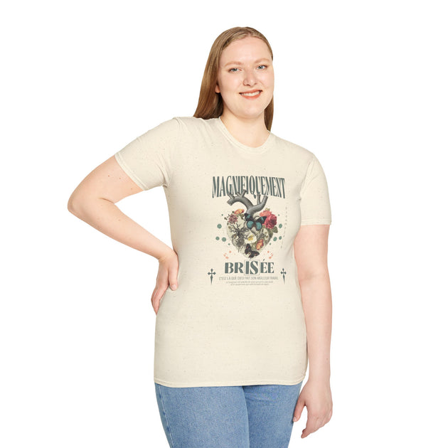 Une femme porte un t-shirt beige chiné avec un motif floral en forme de cœur et du texte français.