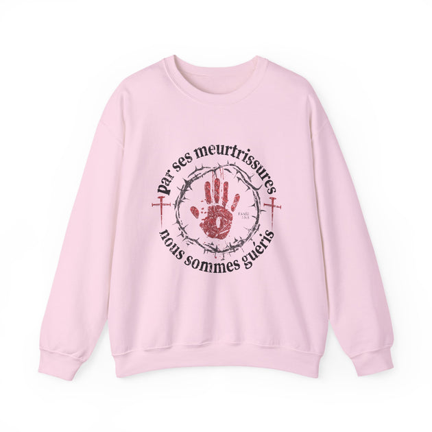 Sweat-shirt rose pâle avec une impression centrale représentant une main, une couronne d'épines et le texte Par ses meurtrissures nous sommes guéris.