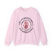 Sweat-shirt rose pâle avec une impression centrale représentant une main, une couronne d'épines et le texte Par ses meurtrissures nous sommes guéris.