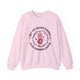 Sweat-shirt rose pâle avec une impression centrale représentant une main, une couronne d'épines et le texte Par ses meurtrissures nous sommes guéris.