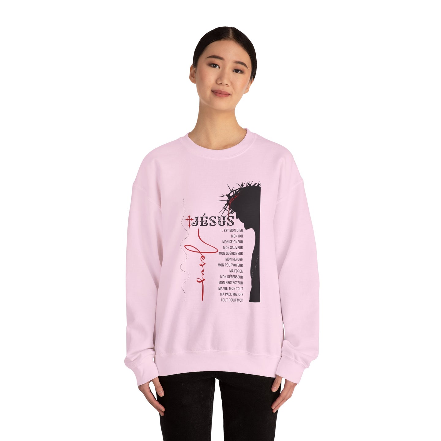 Une femme porte un sweat-shirt rose pâle orné d'un motif religieux sur le thème de Jésus.
