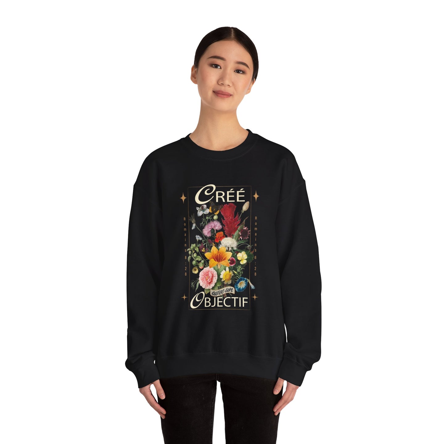 Une femme porte un sweatshirt noir orné d'un motif floral vintage et du texte Créé avec un objectif.