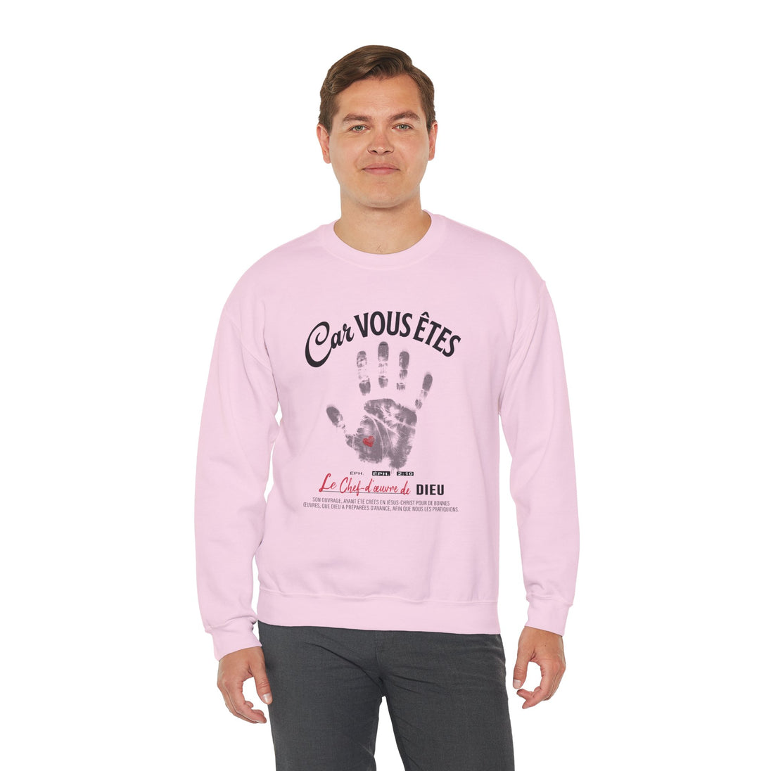 Un homme porte un sweatshirt rose pâle avec une empreinte de main et un texte religieux imprimés.