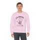 Un homme porte un sweatshirt rose pâle avec une empreinte de main et un texte religieux imprimés.