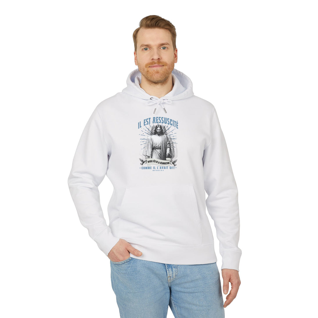 Un homme porte un sweat à capuche blanc avec une illustration religieuse et le texte Il est ressuscité.