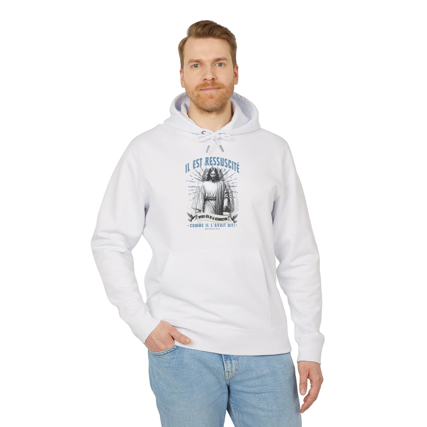 Un homme porte un sweat à capuche blanc avec une illustration religieuse et le texte Il est ressuscité.