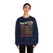 Une femme porte un sweatshirt bleu marine avec une illustration de paysage et un message chrétien.