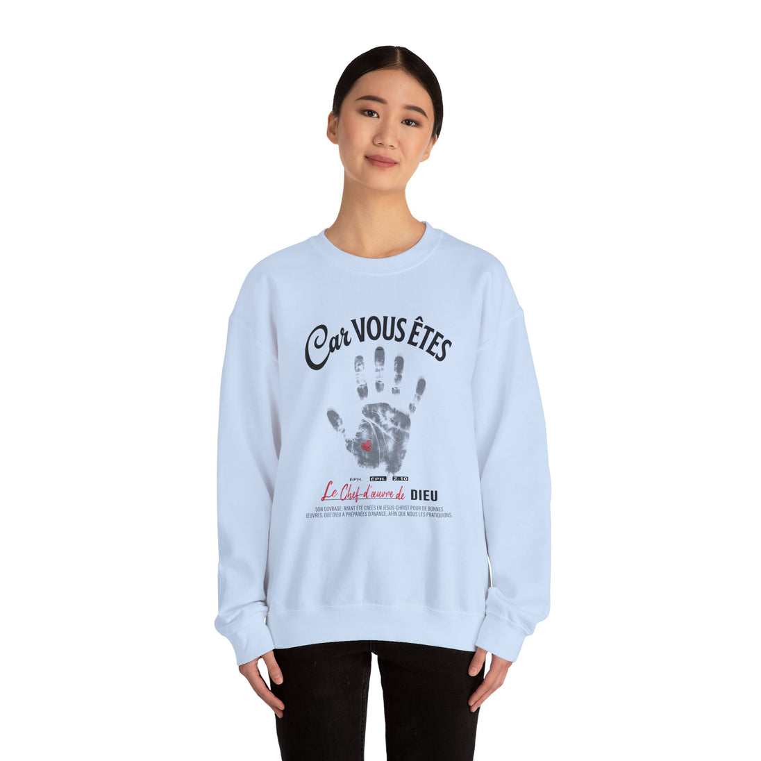 Une femme porte un sweat-shirt blanc avec une empreinte de main et un texte religieux en français.