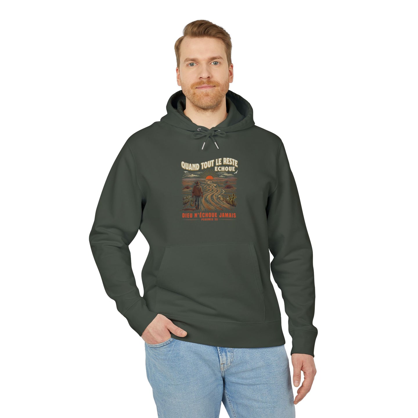 Un homme porte un sweat à capuche vert foncé avec une illustration de paysage et du texte.