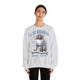 Une femme porte un sweatshirt gris chiné avec une illustration religieuse et du texte en français.