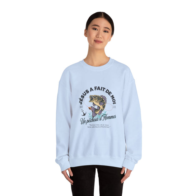 Une femme porte un sweatshirt blanc avec une illustration de poisson et un texte religieux.