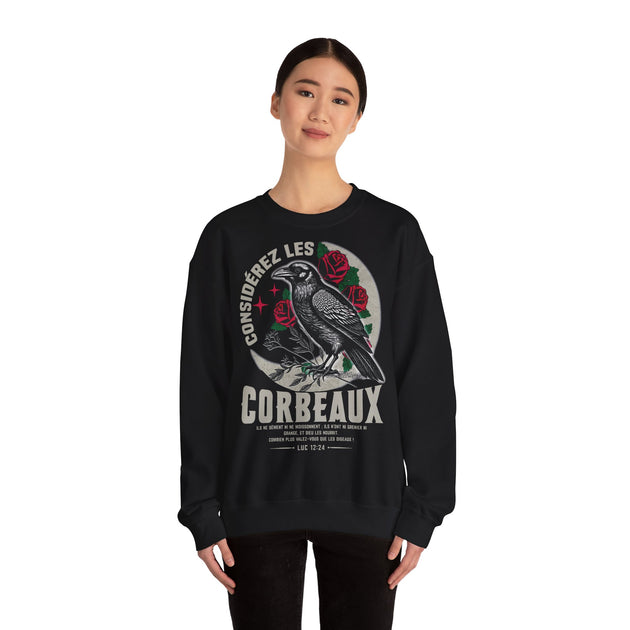 Une femme porte un sweatshirt noir orné d'une illustration de corbeau et d'un verset biblique.