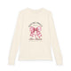 T-shirt à manches longues beige pour enfant avec un motif de nœud rose et une croix chrétienne.