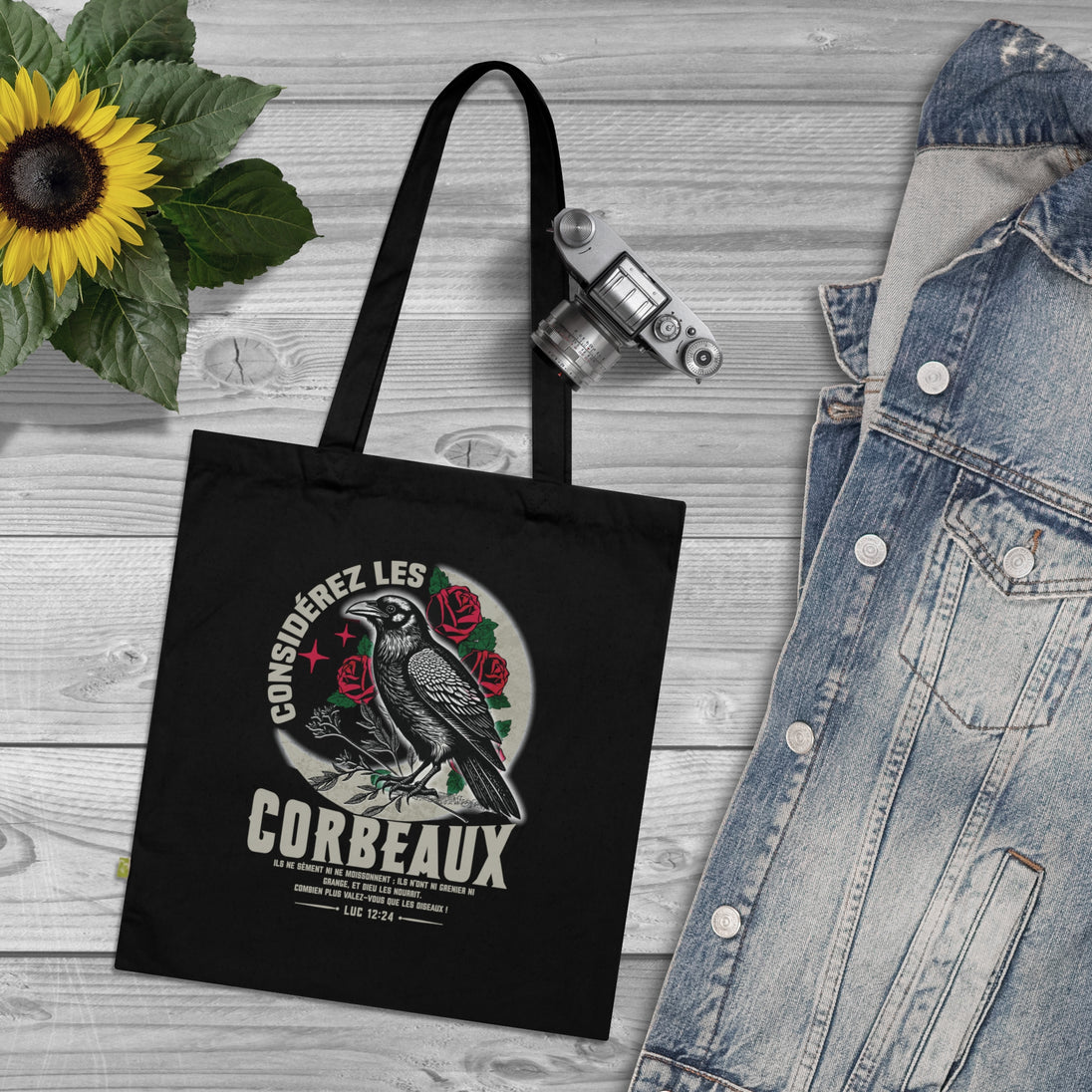 Tote bag noir en coton biologique orné d'une illustration de corbeau et d'un verset biblique.