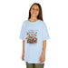 Une jeune fille porte un t-shirt bleu clair orné d'un motif floral vintage et de papillons.