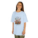 Une jeune fille porte un t-shirt bleu clair orné d'un motif floral vintage et de papillons.
