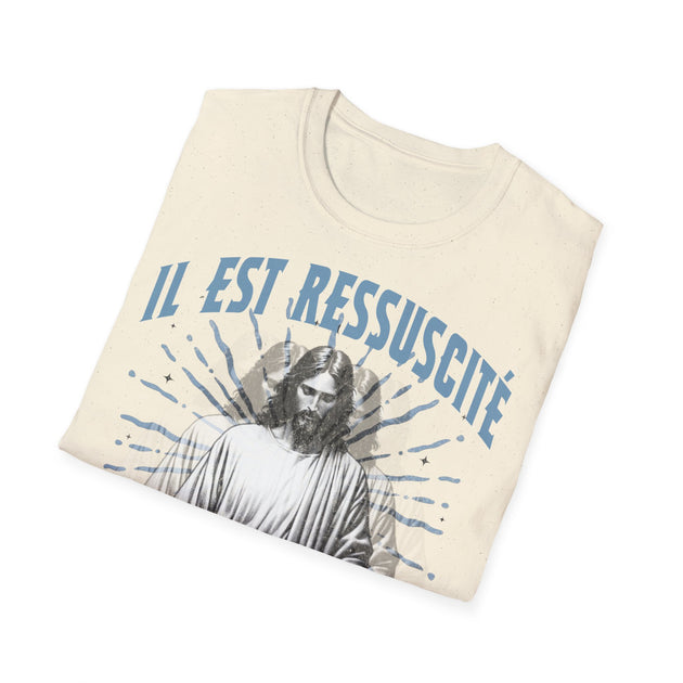 T-shirt beige en coton avec l'inscription bleue Il est ressuscité et une illustration de Jésus.