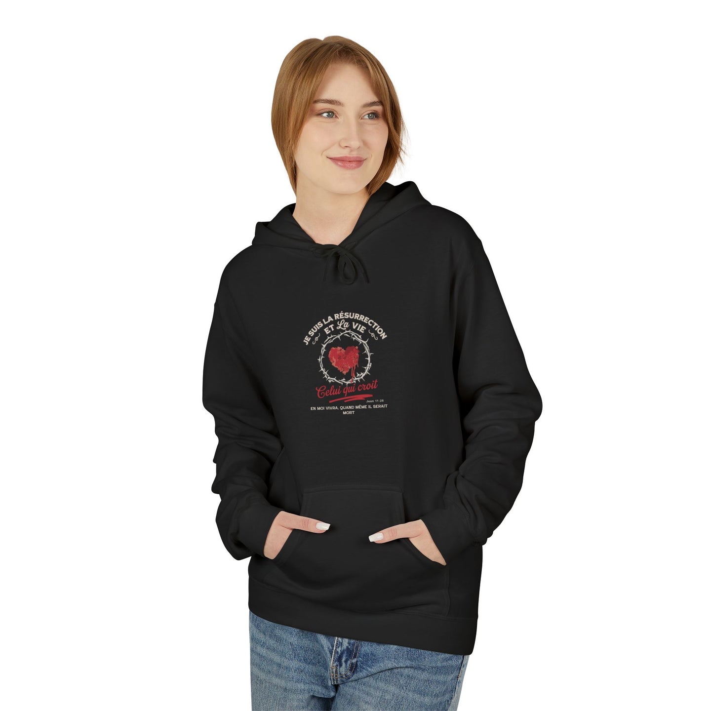 Une femme porte un sweat à capuche noir avec un motif chrétien centré sur la poitrine.