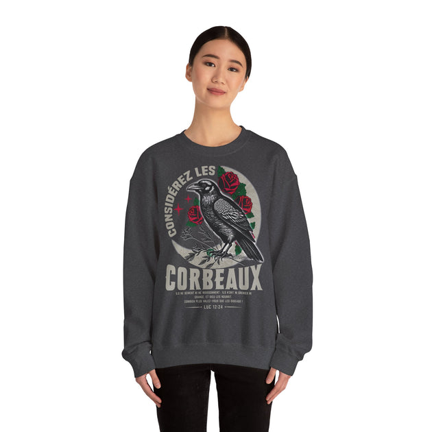 Une femme porte un sweatshirt gris foncé orné d'une illustration de corbeau et de roses.